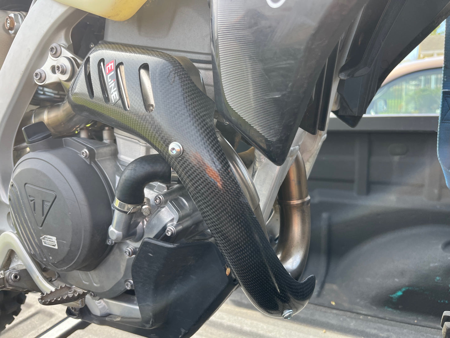 E Line Carbon Fiber Heat Shield installed on Triumph TX250E